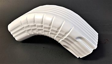 A white plastic object is bent to make it look like a curved wall.