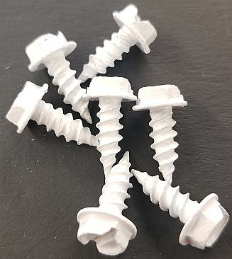 A bunch of white screws are laying on the table